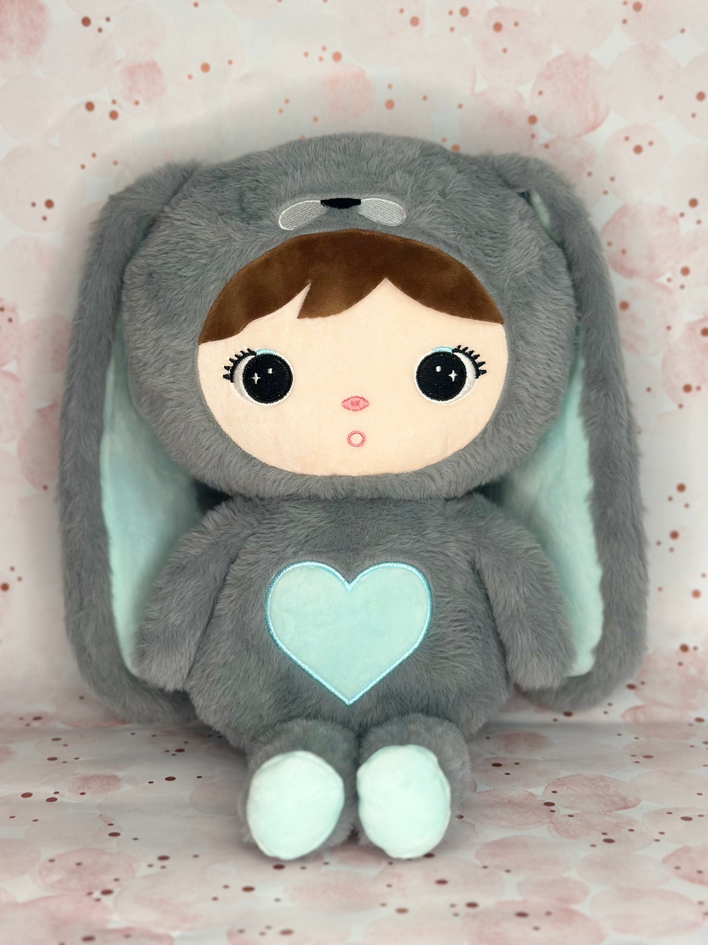 Plush toy with a heart on a light pink background