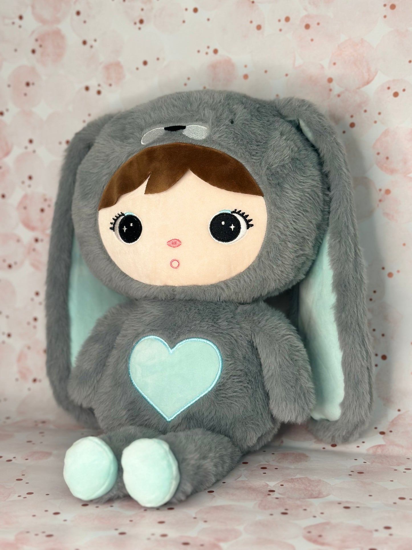Plush toy with a heart design on a soft pink background