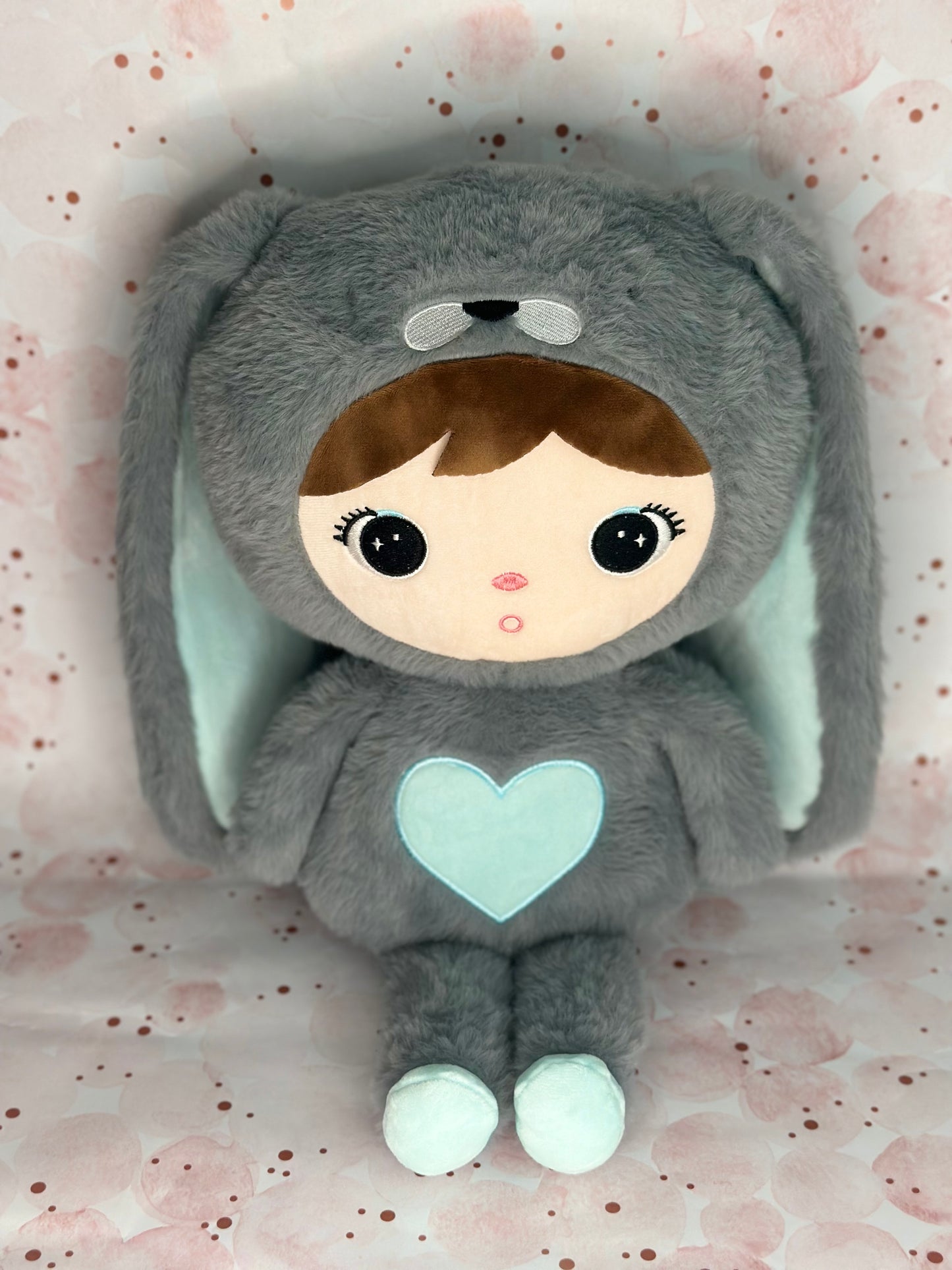 Plush toy with a gray bunny costume on a pink background