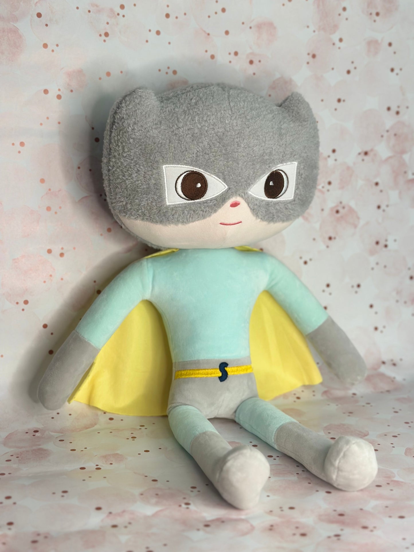 Plush toy with a superhero design on a patterned background