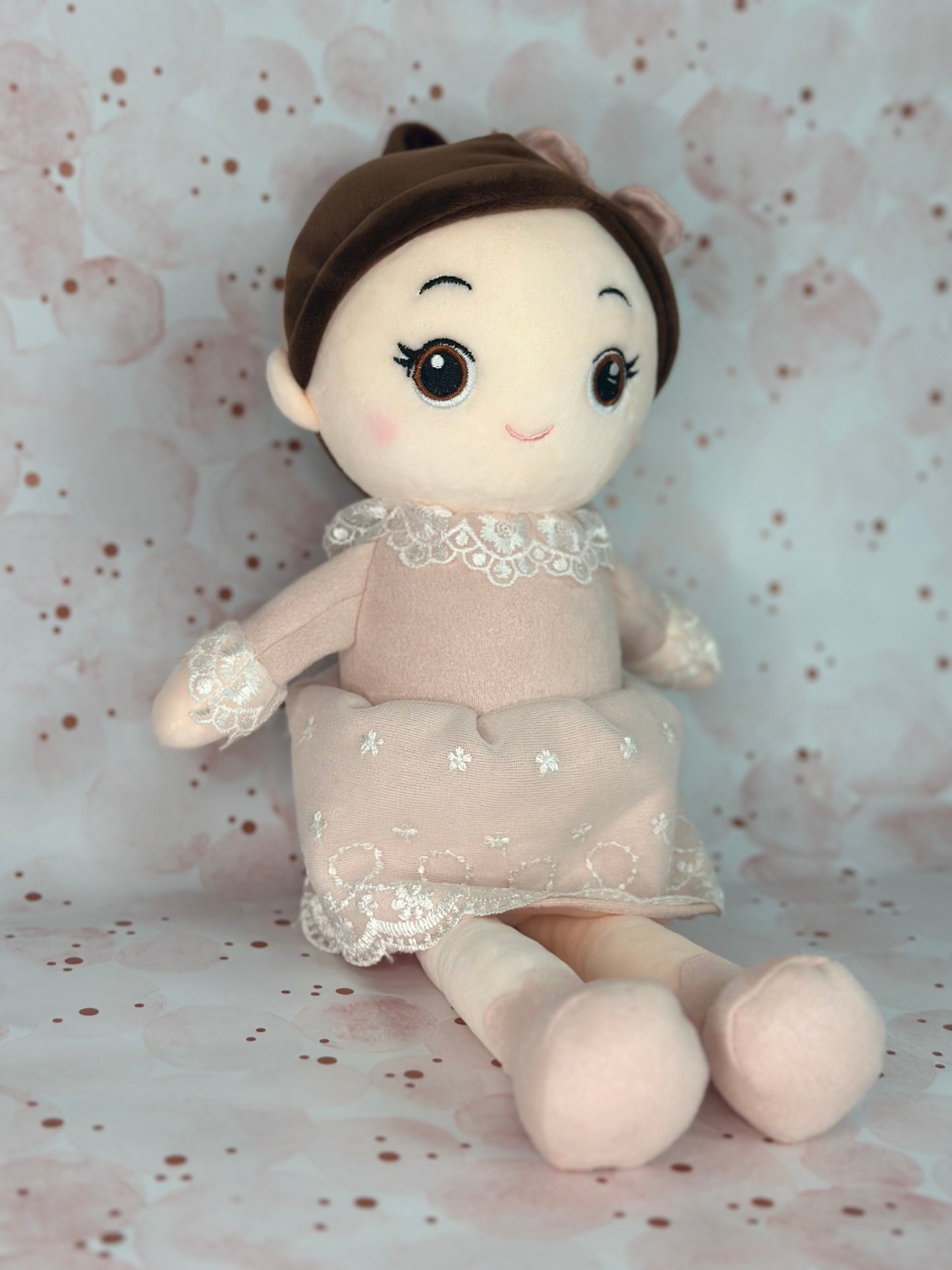 Stuffed doll with a lace dress on a patterned background