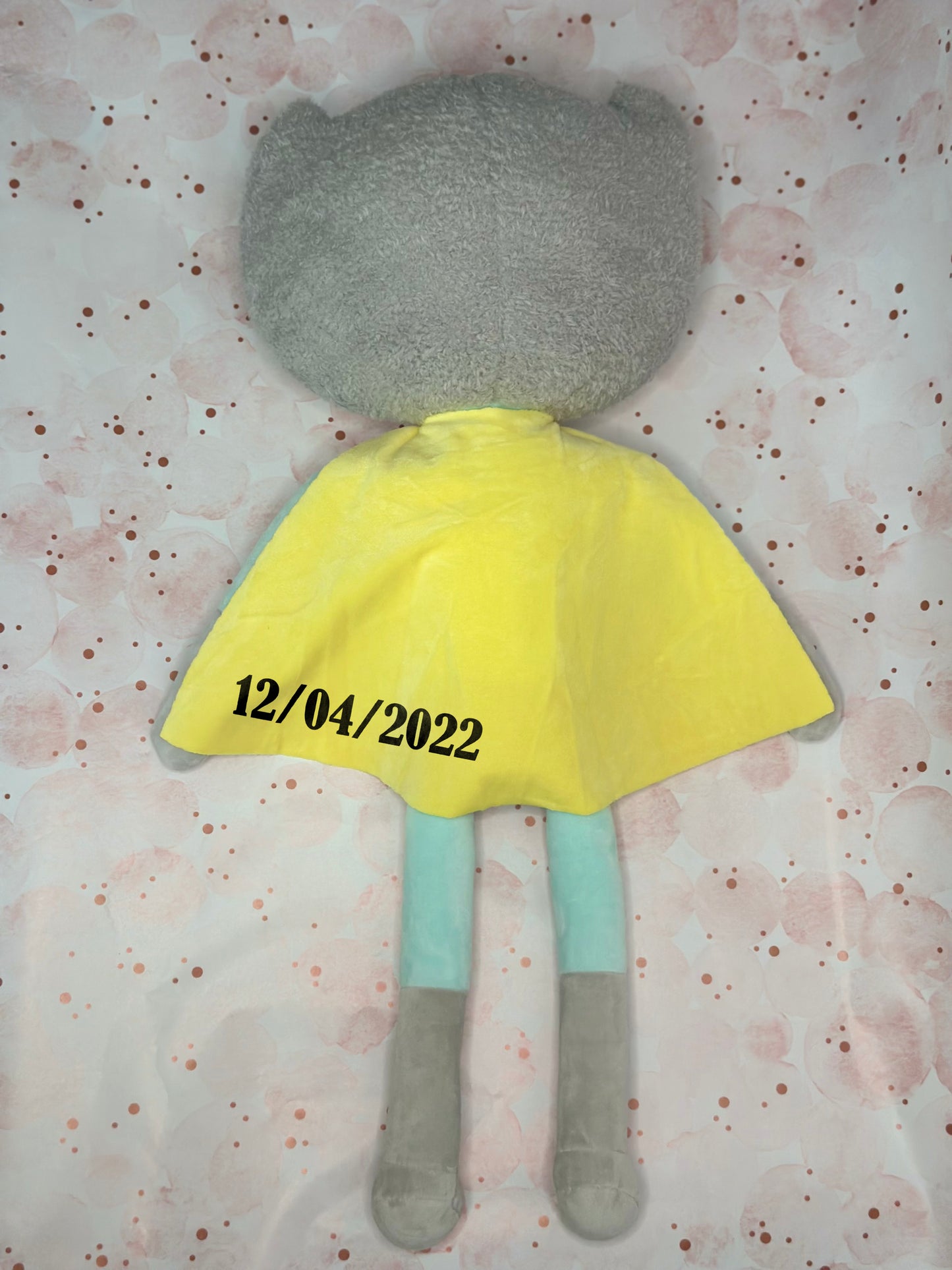 Custom Plush toy with a yellow dress and gray body on a patterned background